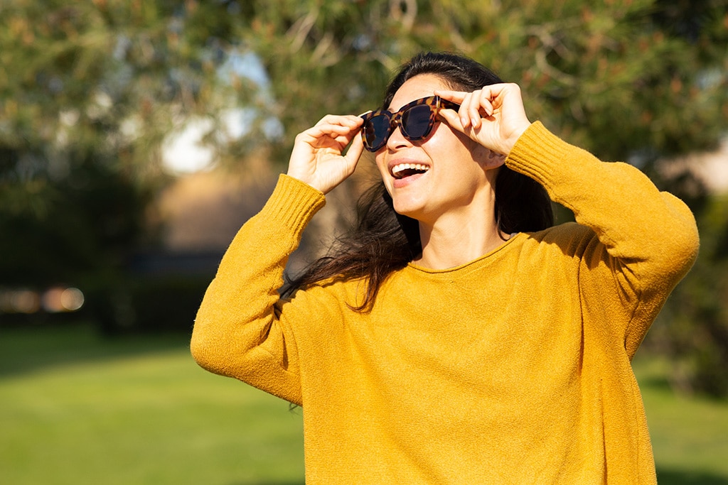 Portrait of woman wearing sunglasses looking away and smiling outside