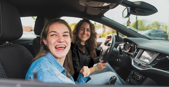 Photo of two people smiling in a car