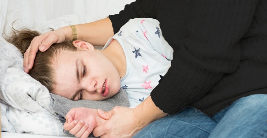 A photo of a person laying down being cared for
