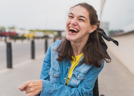 A woman in a wheelchair, smiling
