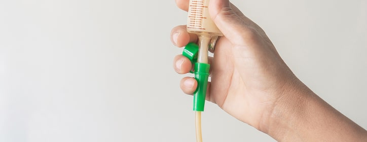 A hand holding tube feeding equipment