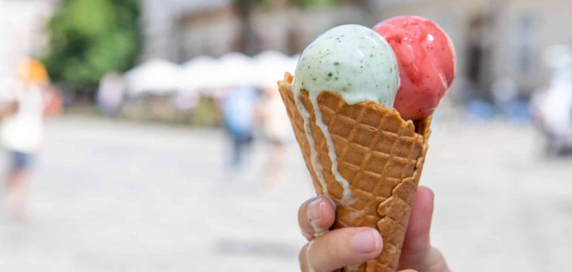 woman hand holding melting ice cream at hot summer day